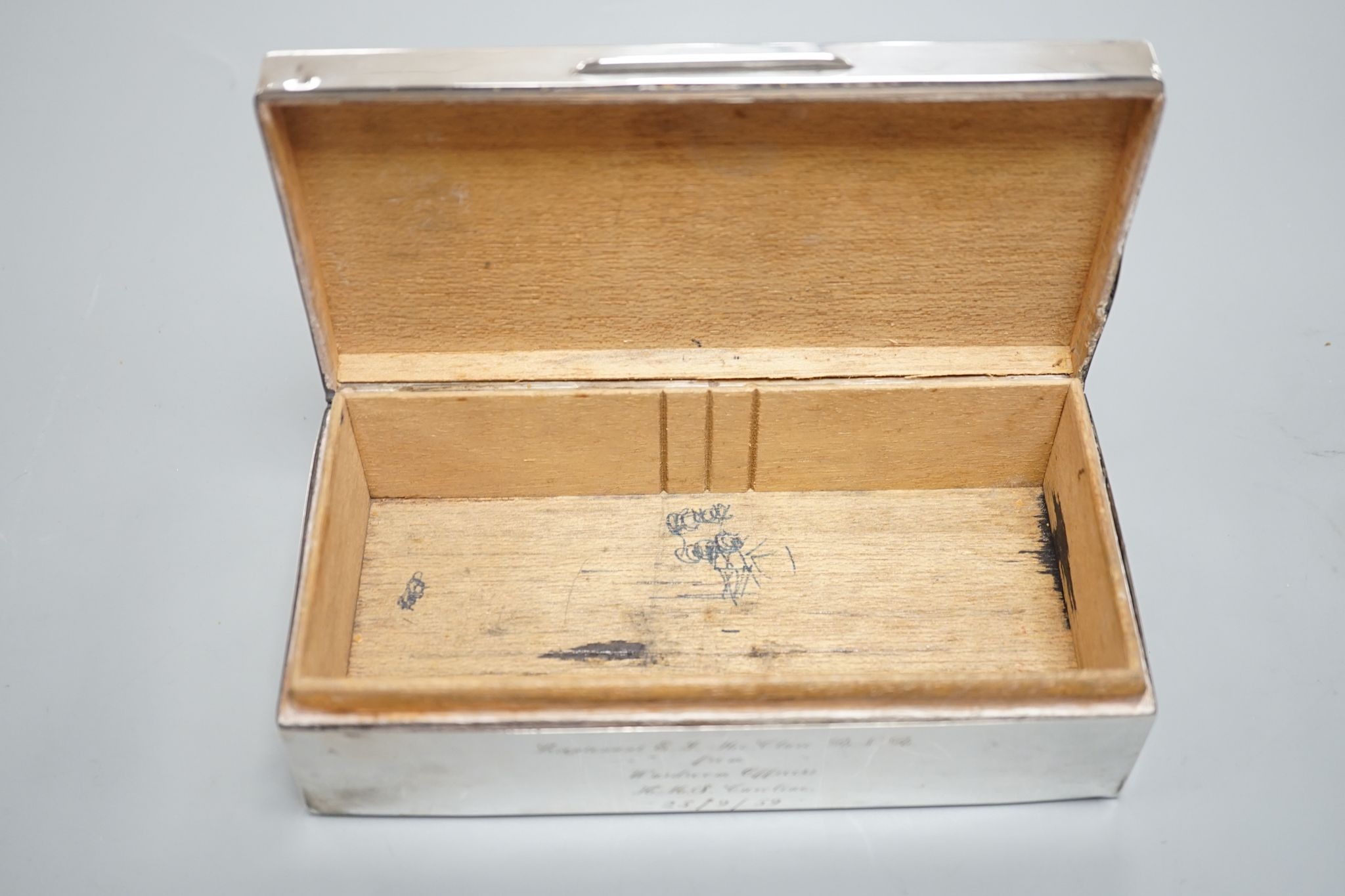 A late 1950's engine turned silver mounted rectangular cigarette box, with engraved inscription, 17.8cm.